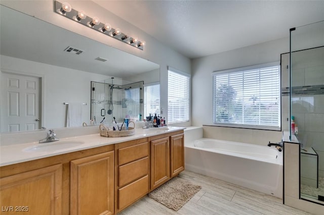 bathroom with double vanity, visible vents, a sink, a shower stall, and a bath