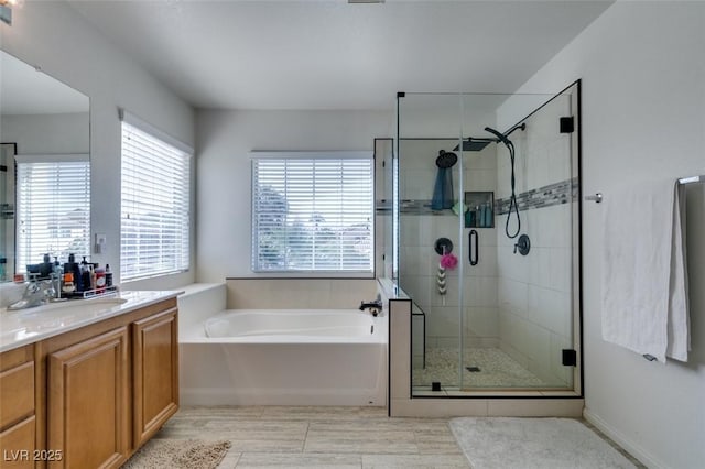 full bath with vanity, a stall shower, and a garden tub