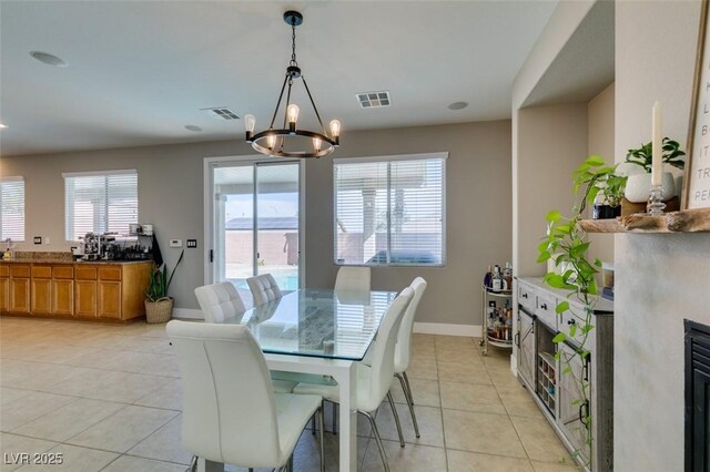 dining space with a chandelier, visible vents, baseboards, and light tile patterned floors