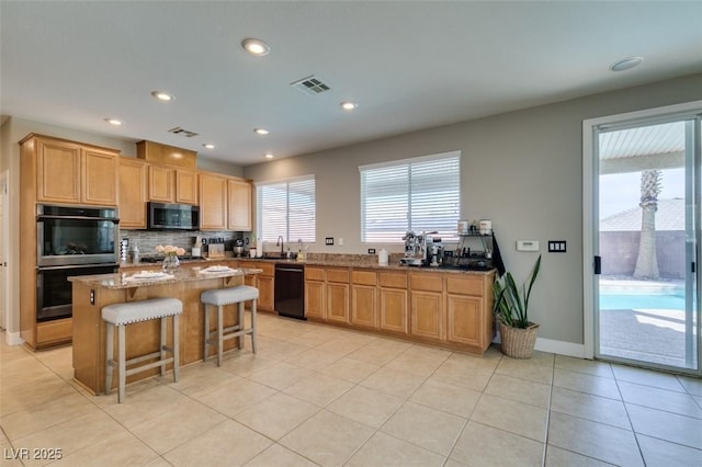 kitchen with appliances with stainless steel finishes, backsplash, light tile patterned flooring, a center island, and stone countertops