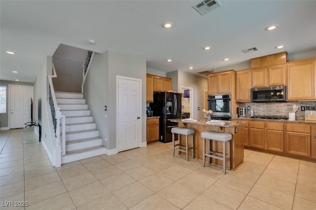 kitchen with stainless steel appliances, decorative backsplash, light tile patterned floors, a kitchen island, and a kitchen breakfast bar