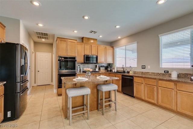 kitchen with stainless steel appliances, light tile patterned flooring, light stone countertops, recessed lighting, and a kitchen breakfast bar