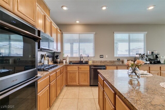 kitchen with light stone counters, light tile patterned flooring, recessed lighting, a sink, and appliances with stainless steel finishes