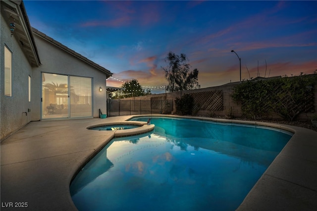 view of pool with a fenced backyard, a pool with connected hot tub, and a patio