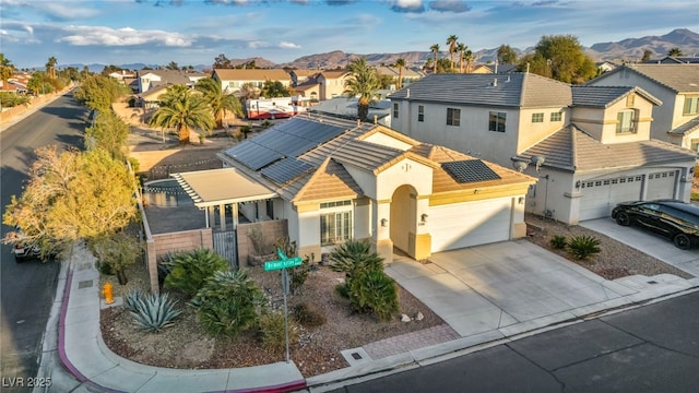 view of front facade featuring a garage, a residential view, concrete driveway, and a tile roof