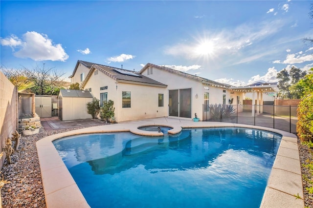 view of pool with a pool with connected hot tub, a patio area, a fenced backyard, and a gate