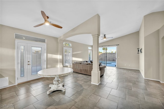 entryway with ceiling fan, vaulted ceiling, baseboards, and decorative columns