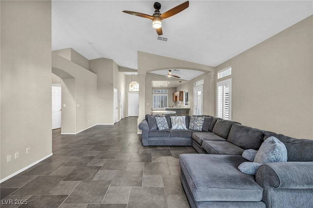 living room featuring arched walkways, ceiling fan, and visible vents