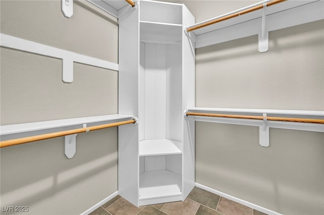 walk in closet featuring dark tile patterned floors