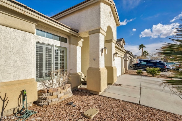 view of property exterior featuring concrete driveway, an attached garage, and stucco siding