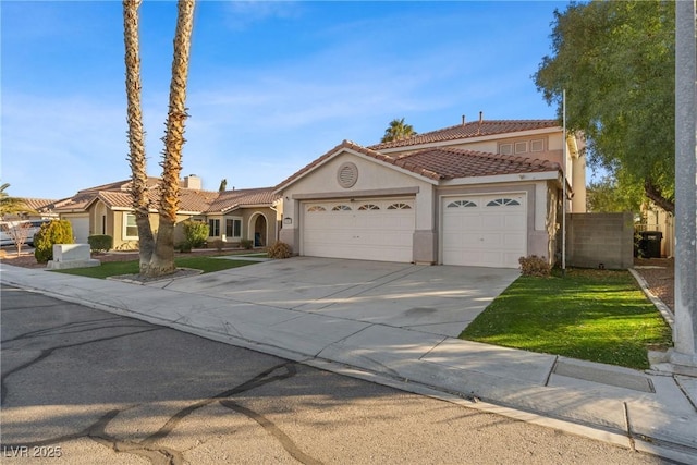 mediterranean / spanish-style house with an attached garage, stucco siding, concrete driveway, and a tiled roof