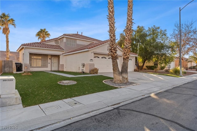 mediterranean / spanish house featuring a tile roof, stucco siding, concrete driveway, a front yard, and a garage