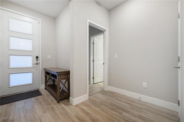 foyer with wood tiled floor and baseboards