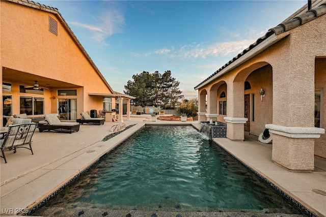 outdoor pool with a patio and ceiling fan