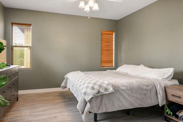 bedroom with baseboards, light wood-style floors, and ceiling fan