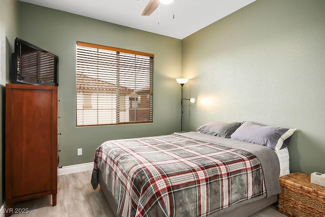 bedroom with wood finished floors, baseboards, and ceiling fan