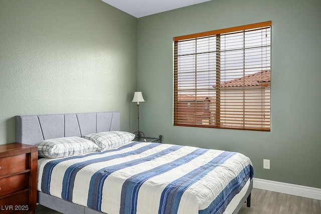 bedroom featuring baseboards and wood finished floors