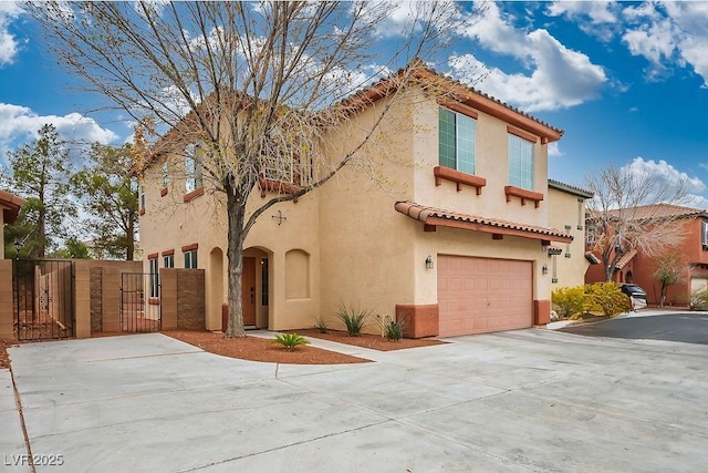 mediterranean / spanish-style home with stucco siding, driveway, a gate, a garage, and a tiled roof