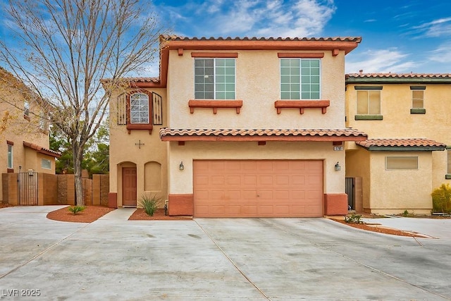 mediterranean / spanish house featuring concrete driveway, a gate, and stucco siding