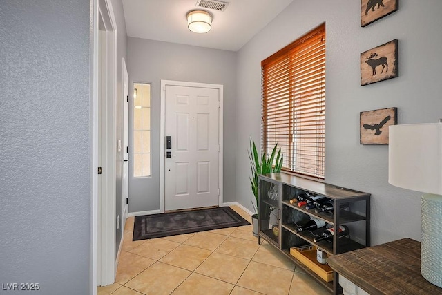 entryway featuring light tile patterned floors, visible vents, and baseboards