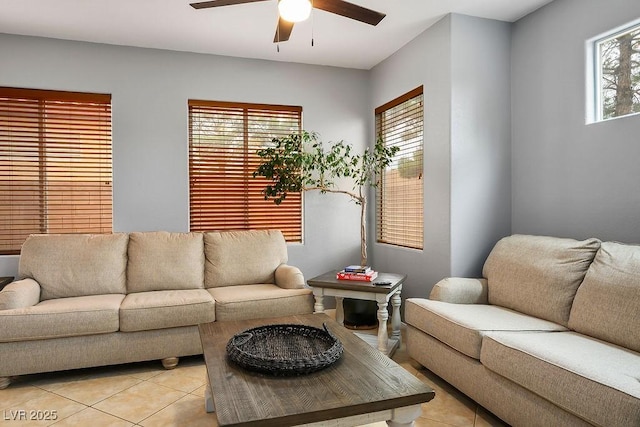 living area with light tile patterned floors and a ceiling fan