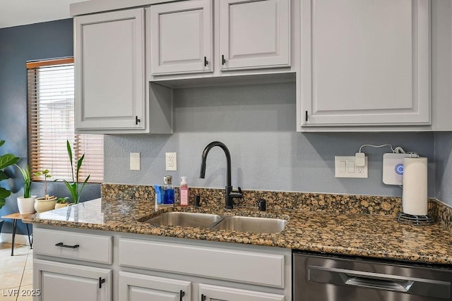 kitchen featuring a sink, dark stone counters, dishwasher, and white cabinetry