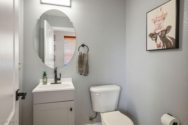 bathroom featuring toilet and vanity