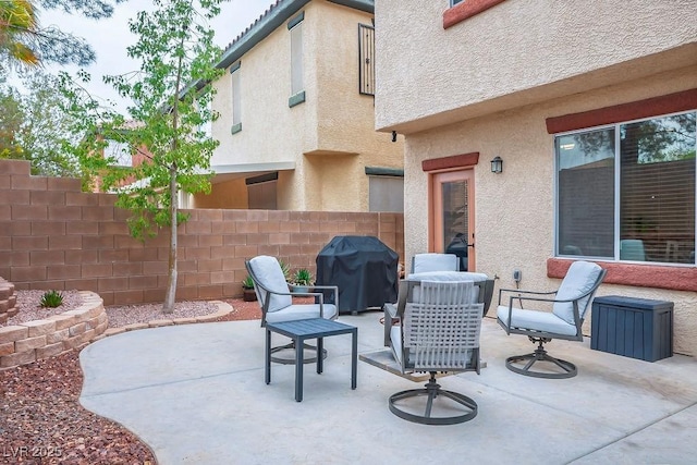 view of patio with a grill and fence