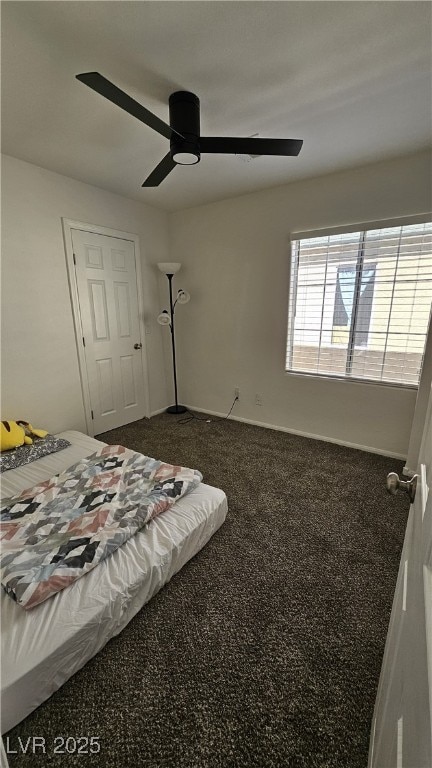 bedroom featuring dark colored carpet and a ceiling fan