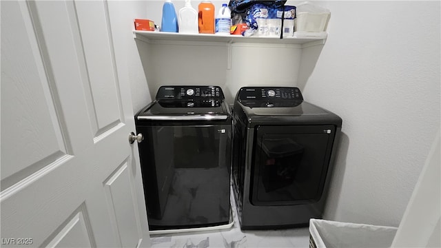 clothes washing area with marble finish floor, laundry area, and washing machine and dryer