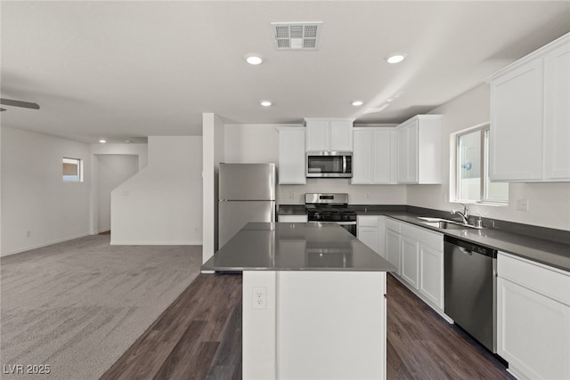 kitchen featuring stainless steel appliances, visible vents, open floor plan, white cabinetry, and a sink