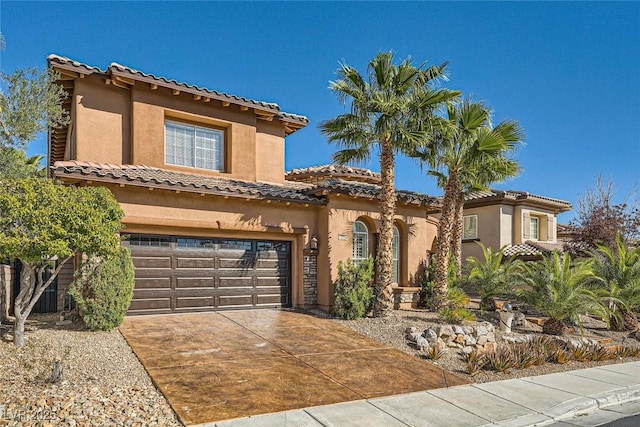 mediterranean / spanish-style house featuring concrete driveway, an attached garage, and stucco siding