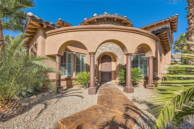 mediterranean / spanish home with stone siding and stucco siding