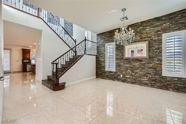 entryway with a high ceiling, visible vents, stairs, marble finish floor, and an inviting chandelier