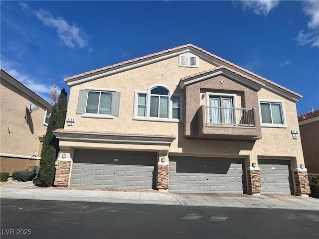 view of front of home featuring a garage, stone siding, a balcony, and stucco siding