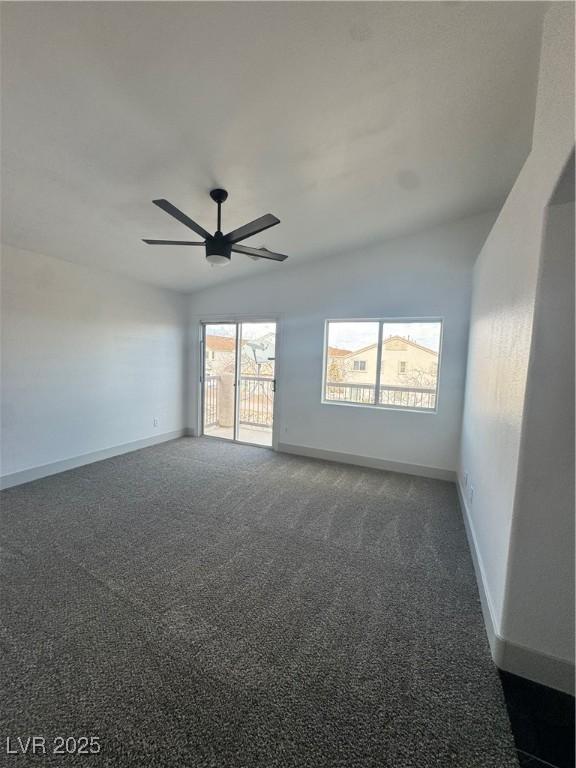 carpeted empty room featuring lofted ceiling, ceiling fan, and baseboards