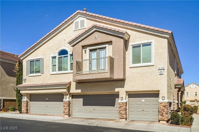 multi unit property featuring stone siding, stucco siding, and a garage