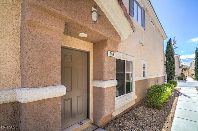 view of exterior entry featuring stucco siding