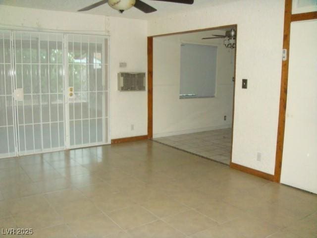 spare room with ceiling fan and baseboards