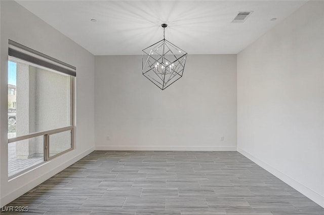 empty room featuring a notable chandelier, baseboards, visible vents, and a wealth of natural light