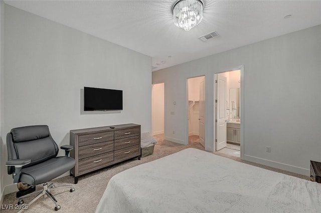 carpeted bedroom with a chandelier, a walk in closet, visible vents, and baseboards