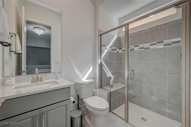 bathroom featuring toilet, a shower stall, and vanity