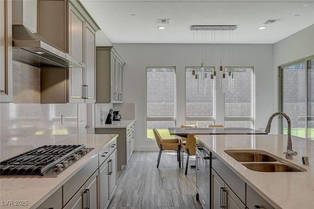 kitchen featuring stainless steel appliances, visible vents, gray cabinetry, a sink, and wall chimney exhaust hood