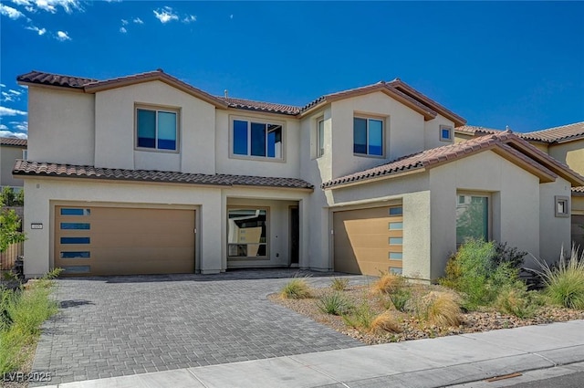 view of front of property featuring a garage, decorative driveway, and stucco siding