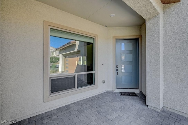 entrance to property with stucco siding