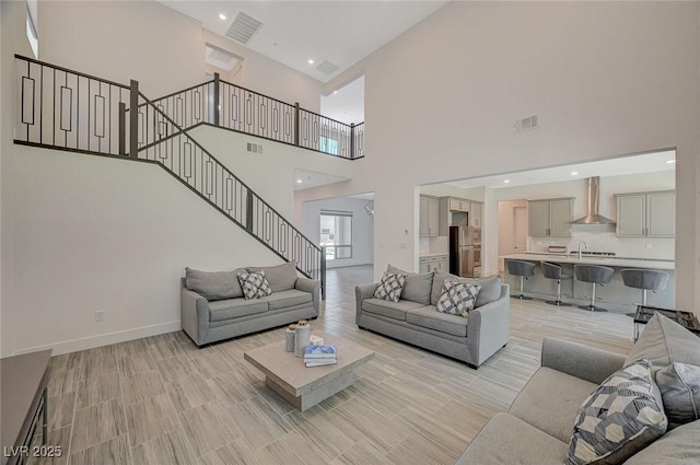 living room with recessed lighting, visible vents, baseboards, and stairs