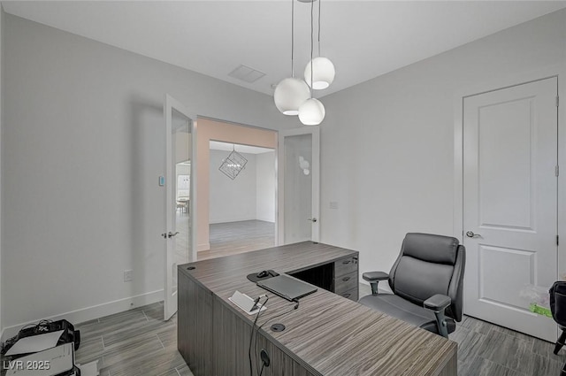 office with wood tiled floor, visible vents, and baseboards