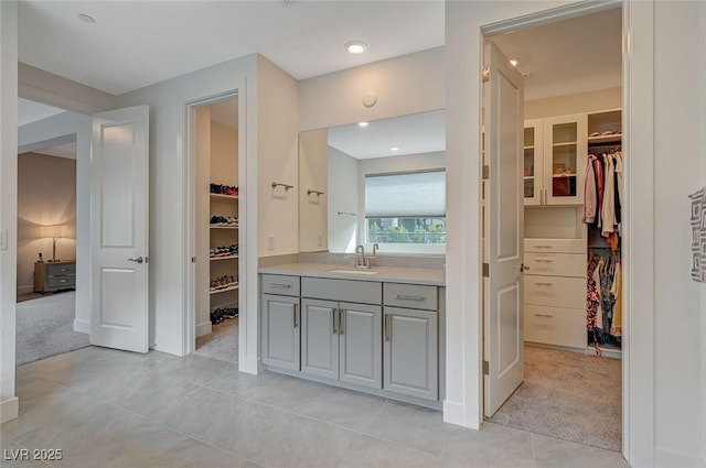 bathroom featuring a spacious closet, vanity, and tile patterned floors