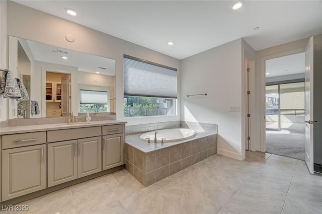 bathroom with a walk in closet, a garden tub, recessed lighting, vanity, and tile patterned floors