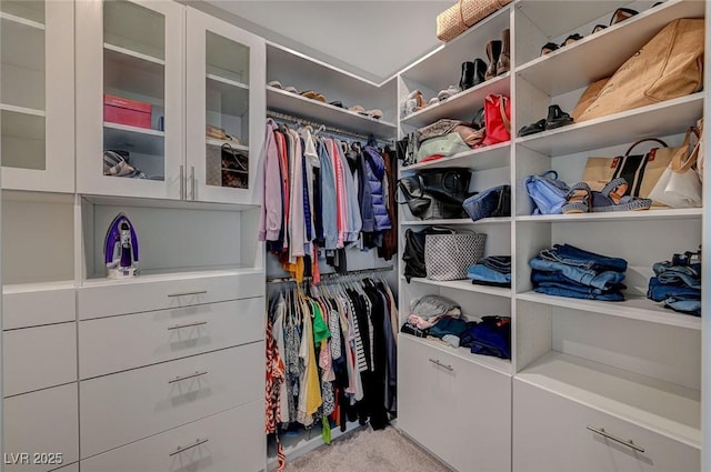 walk in closet featuring light carpet